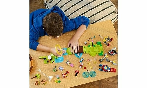 Child assembling building block toys on a table.