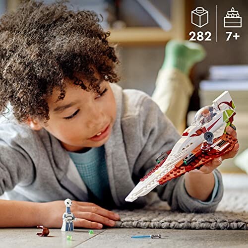 Child playing with a toy spaceship on the floor.