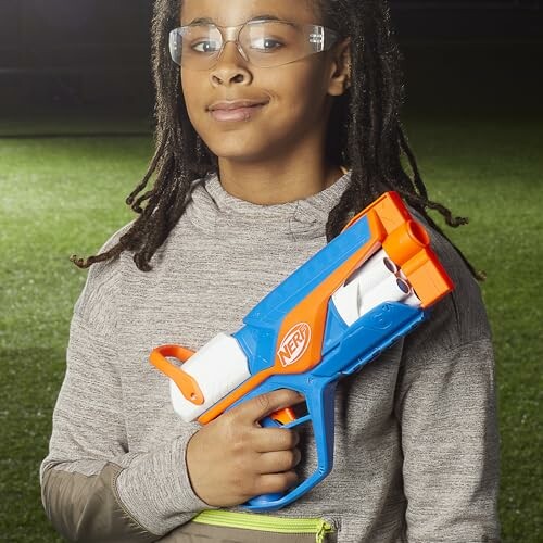 Child holding a Nerf gun outdoors