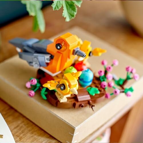 Lego bird model on a branch with flowers