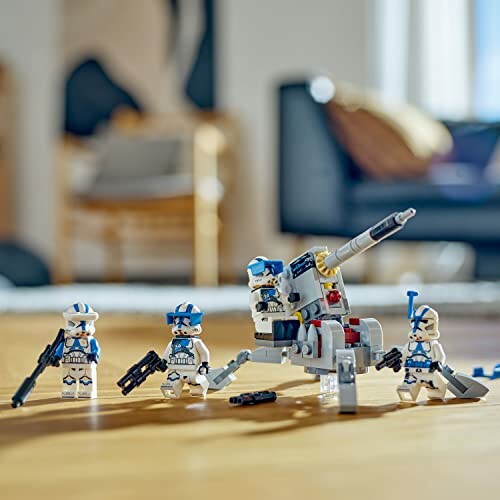 Lego stormtroopers with a battle set on a wooden table.